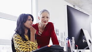 Two women at work looking at a computer screen