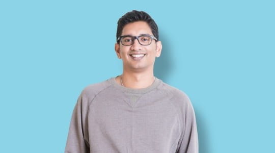 Young man in glasses smiling at camera
