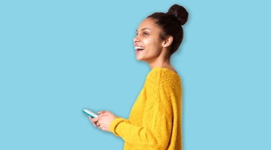 Young woman in yellow top holding smartphone
