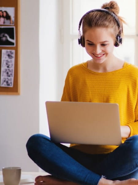 Student working on a laptop and wearing headphones