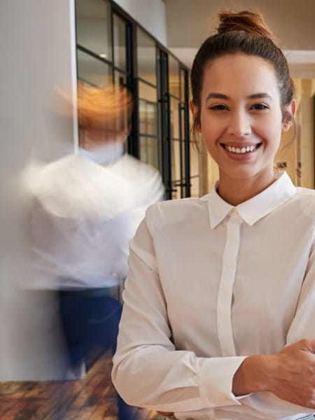 Young business woman standing in office corridor.