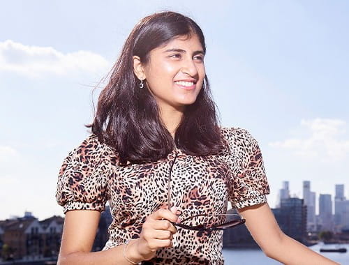 Audit trainee and ACA student Ashwini Poopalasingham standing in front of the Thames river, London city, UK