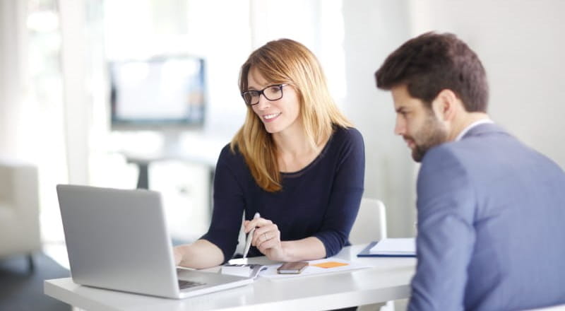 Woman and man working at a laptop in modern looking office