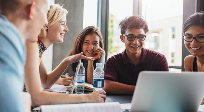 Group of people sat round laptop