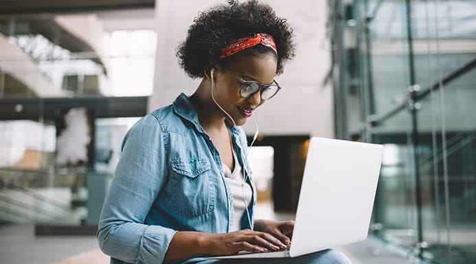 A person sitting at a laptop in an office building