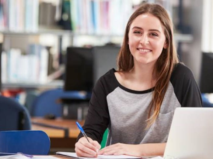 Young woman sat by laptop