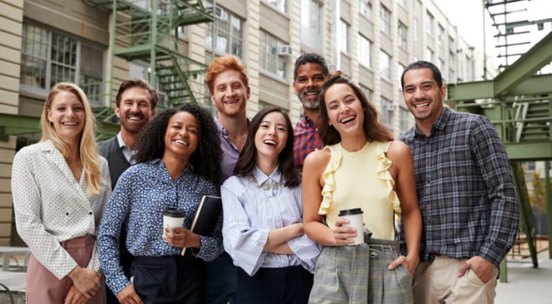 Diverse group of young co-workers outside office.