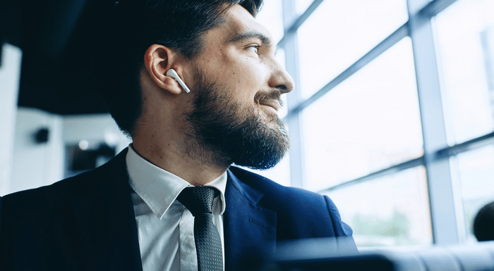 A man commuting, wearing AirPods.